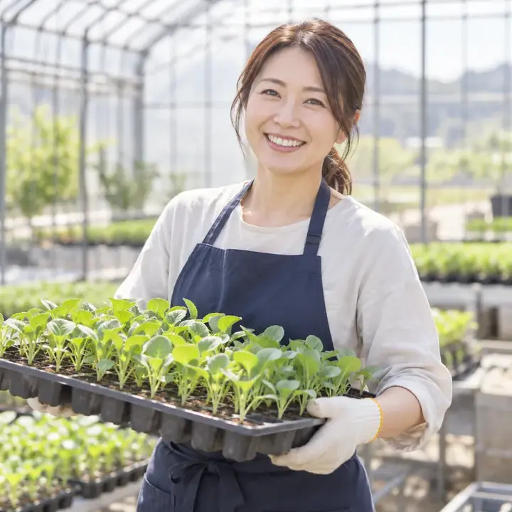 苗のトレーを持つ農園のスタッフ